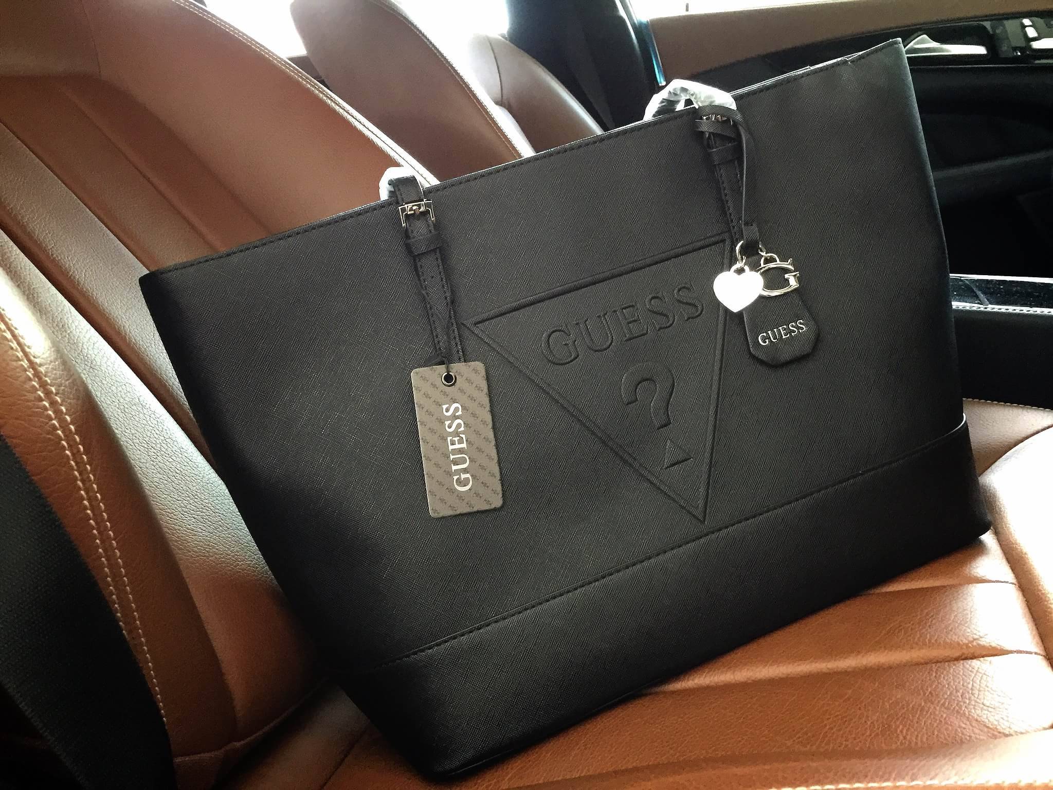 Guess Saffiano Shopping Bag กระเป๋าถือและคล้องบ่าทรงช้อปปิ้งใบใหญ่ หนังSaffiano ใส่เอกสารขนาด A4 ได้ จุของได้เยอะ ด้านหน้าสลักแบรนด์หนังลายนูนพร้อมประดับtagสายหนังถอดออกได้ เปิดปิดด้วยซิปเดียวด้านบน ภายในบุผ้าติดโลโก้ มีช่องเล็กและข่องใส่โทรศัพท์ เรียบง่า