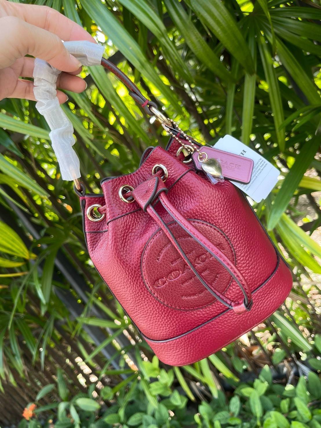 COACH DEMPSEY BUCKET BAG 15 WITH COACH PATCH AND HEART CHARM สวยงามด้วยดีไซน์ทรงตะกร้าแบบมินิมอลแสนน่ารัก ดีเทลสะดุดตา รูปทรงจดจำง่าย ถือแบบชิคๆ หรือยิ่งไปกว่านั้น สายสะพายของกระเป๋าก็สามารถถอดออกเพื่อเปลี่ยนรูปแบบการสะพายได้ทั้งแบบสะพายไหล่และสะพายคาดลำต