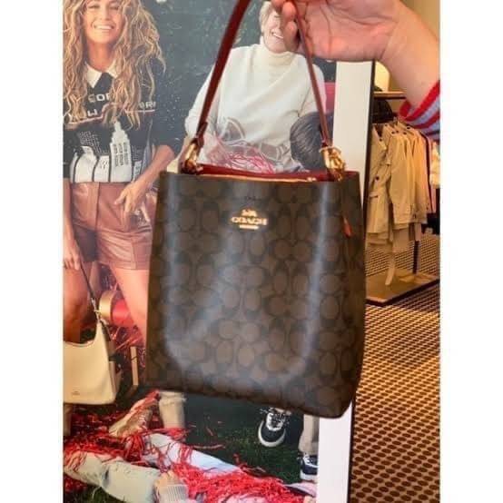 COACH SMALL TOWN BUCKET BAG IN SIGNATURE สำหรับสาวแฟชั่นที่ชอบรายละเอียดชิคๆ ดีไซน์สุดเก๋ แนะนำเลยสำหรับกระเป๋าทรงบักเก็ตใบนี้ เชื่อว่าสาว ๆ หลายคนชื่นชอบ เป็นไอเทมที่สามารถแมทช์ได้กับเสื้อหลากหลายสไตล์ บรรจุของได้เยอะโดยที่กระเป๋าไม่เสียทรง แบ่งช่องใช้งา