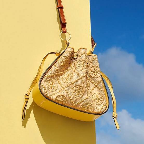 TORY BURCH T Monogram Straw Bell Bag กระเป๋าสะพายข้างรุ่นคลาสสิกที่ได้แรงบันดาลใจจากการควิลท์แบบดั้งเดิมของเพนซิลเวเนีย คอลเลกชันบ่งบอกถึงความมีสไตล์เหนือกาลเวลา รูปทรงเรียวโดดเด่น ปักทอลายแบรนด์อย่างสวยงาม เปิด ปิดด้วยเชือกรูด ด้านในช่องโล่งกว้าง ซับในผ้