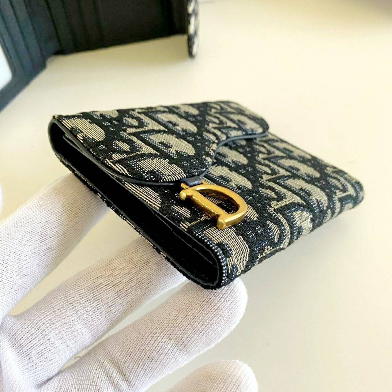VIP 】DIOR WALLET MONOGRAM SADDLE LOTUS กระเป๋าสตางค์ 3 พับ วัสดุหนังแท้ และผ้า Jacquard อย่างดี ทอสวยงามที่สุด ผสมผสานความสง่างามและคลาสสิกที่เข้ากับยุคสมัย ด้านหน้าโดดเด่นด้วยซิกเนเจอร์ของ Christian Dior อะไหล่สีทองอ่อน เงางาม เป็นอีกหนึ่งรุ่นที่ดาราเชเล