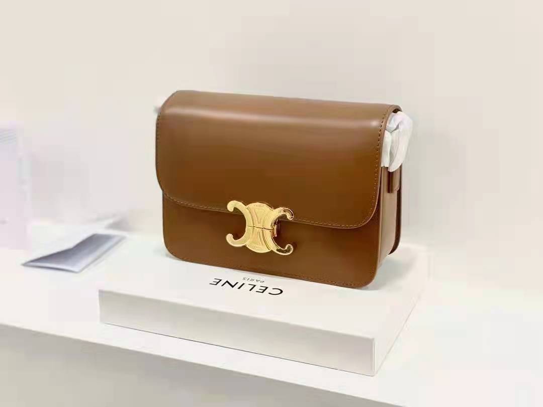 Celine MEDIUM TRIOMPHE BAG IN SHINY มีรูปทรงเป็นกล่องคล้ายกับกระเป๋า Classic Box แต่มีการออกแบบโลโก้ที่สะดุดตาแบบวินเทจ ด้วยดีไซน์ที่ดูโฉบเฉี่ยว แต่คงความคลาสสิคอย่างเต็มเปี่ยม ทำให้เป็นที่ดึงดูดความสนใจของสาวๆ สายสะพายสามารถปรับระดับได้ มีความคล่องตัวในก