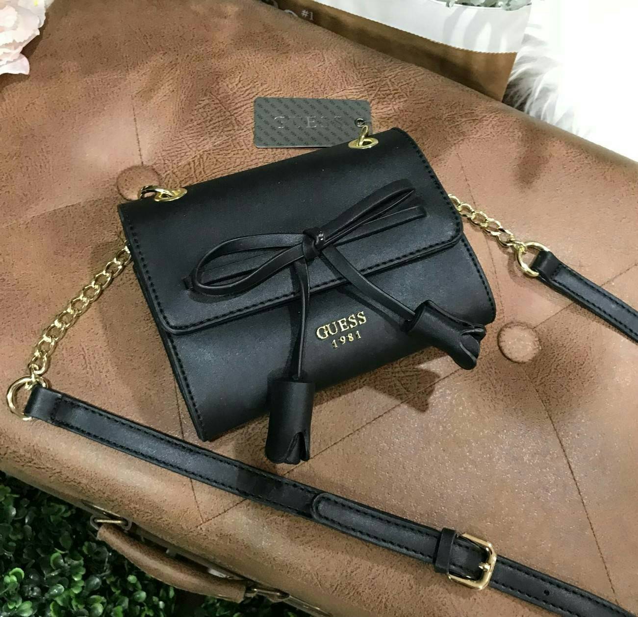 New Arrival! Guess Detail Crossbody Flap Bag Y2019 กระเป๋าสะพายรุ่นใหม่ล่าสุดขนาดมินิกำลังน่ารักวัสดุหนังเรียบอยู่ทรงด้านหน้าประดับโบว์พร้อมโลโก้แบรนด์ดูมีดีเทลเปิดปิดด้วยฝาปิดกระดุมแม่เหล็ก ซับในลายแบรนด์ ภายในมีช่องซิปและช่องเล็กใส่ของสามารถใส่ iphone ไ
