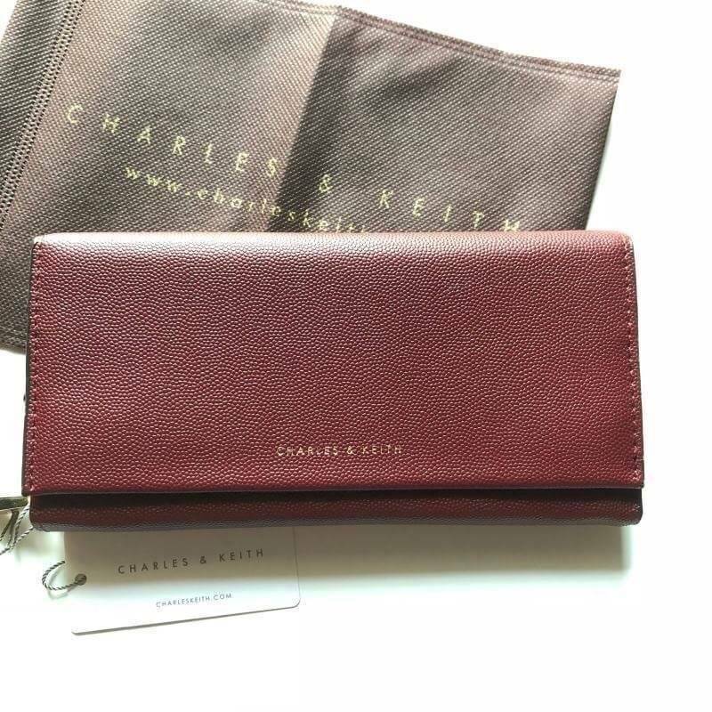 CHARLES & KEITH LONG WALLET กระเป๋าสตางค์ใบยาวแบบ 2 พับ หนังคาเวียร์ อะไหล่สีทอง และพู่สวยหรูมากค่ะด้านหน้าปั้มโลโก้แบรนด์ เปิดปิดด้วยฝาปิด ภายในมี1ช่องซิปแชะช่องเก็บบัตรหลายช่องใช้งานใส่ช่องใส่ธนบัตร แยกเป็นสัดส่วน ใบนี้สุดคุ้มเลยค่า