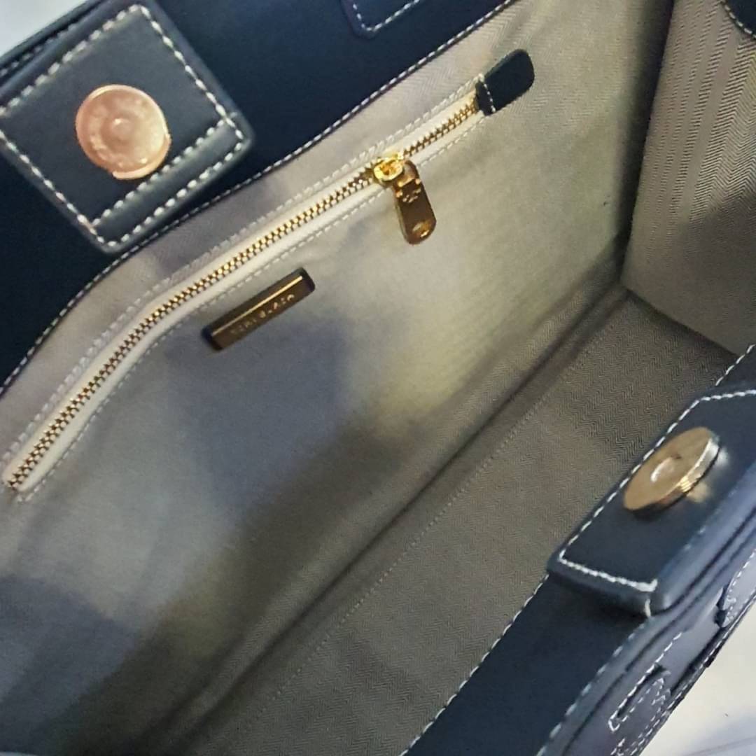 OUTTLET 】TORY BURCH TOTE BAG วัสดุ CANVAS ทั้งใบตัดด้วยหนังแท้สี NAVY ตัวกระเป๋าตั้งอยู่ทรงสวย แต่งโลโก้แบรนด์ด้านหน้า ด้านข้างมีกระดุม สามารถขยายทรงได้ ด้านในเปิดปิดด้วยกระดุมแม่เหล็ก ช่องกว้างหลักหนึ่งช่องและช่องซิปอีกช่อง สามารถใส่กระเป๋าสตางค์ยาว สมุด