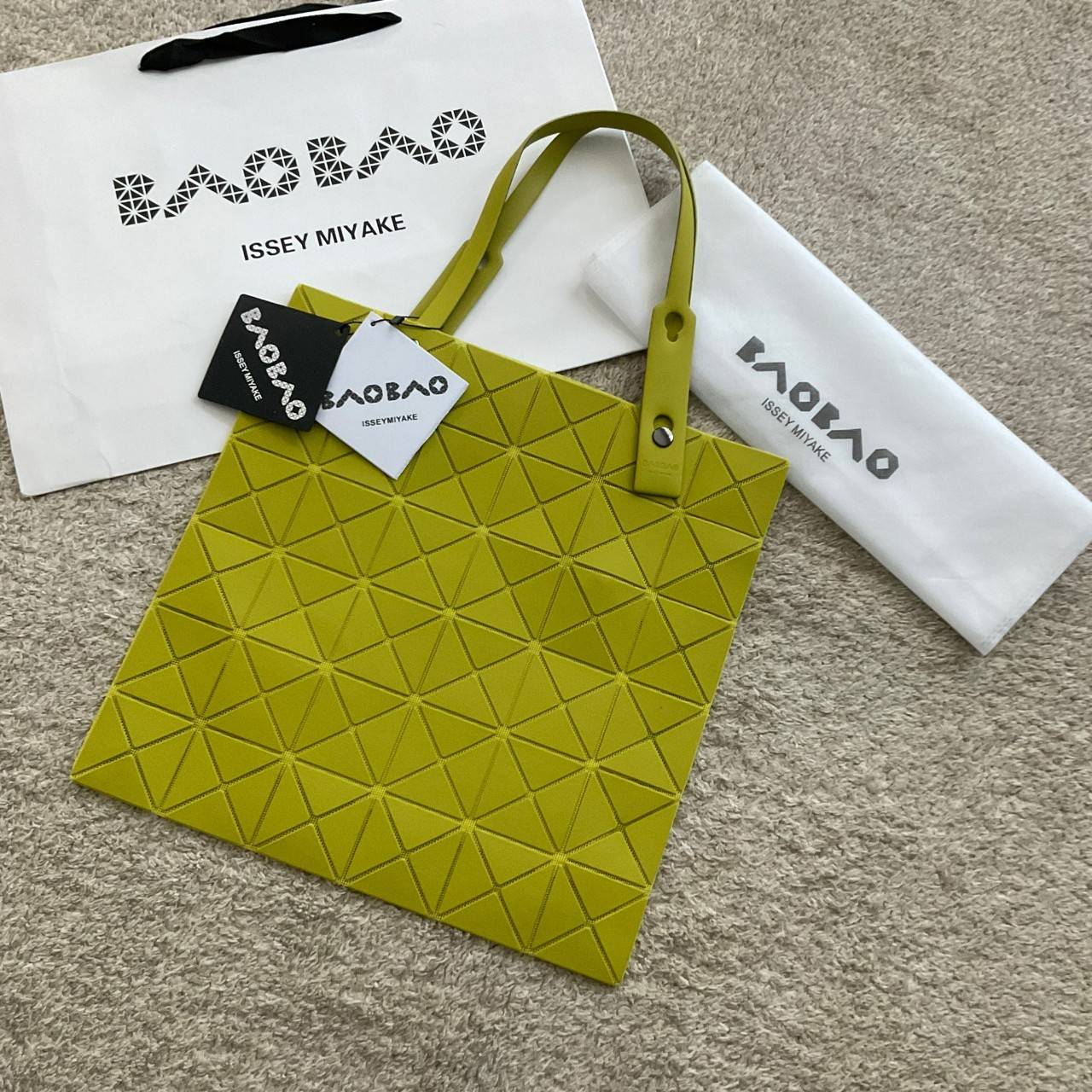 BAO BAO ISSEY MIYAKE LUCENT ONE-TONE กระเป๋าสะพายไหล่ ทรงโท้ท ใบใหญ่สวยมาก ปรับได้หลายทรงตามเอกลักษณ์เฉพาะของแบรนด์นี้ วัสดุ 100% POLYESTER PARTLY: SYMYHETIC LEATHER ด้านในใส่ของได้เยอะมาก ใส่ไอแพด สมุดโน้ตได้สบายเลย วัยทำงานหรือวัยนักศึกษา อย่างน้อยต้องม