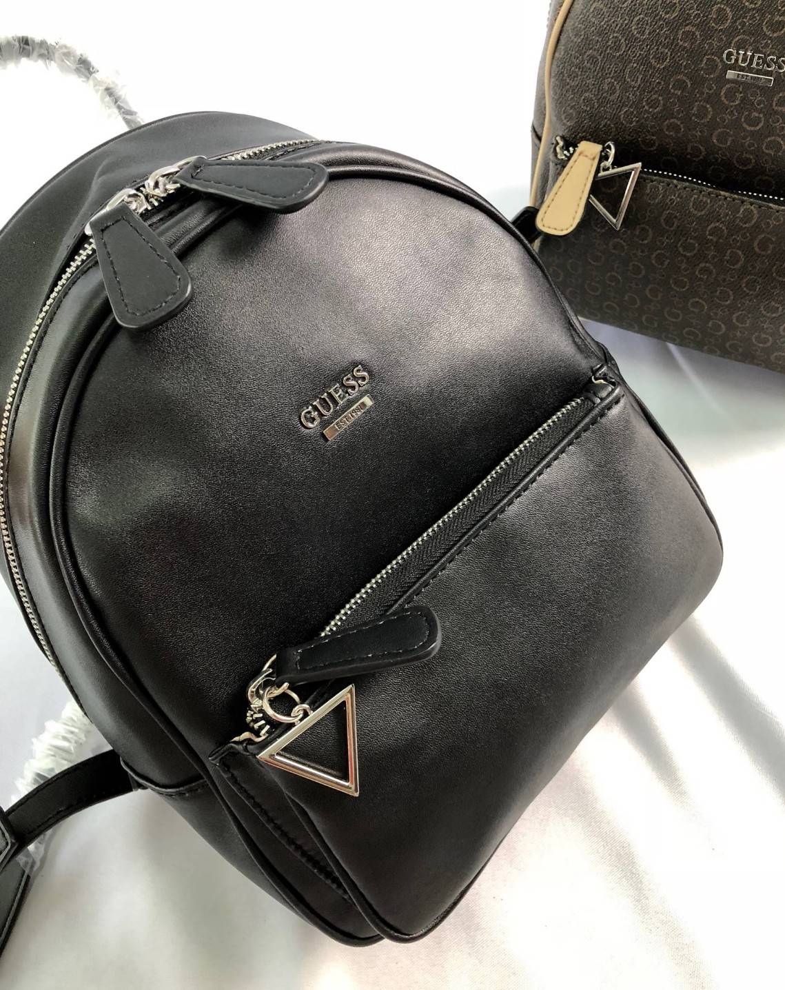 GUESS PANDORE BACKPACK กระเป๋าสะพายหลัง วัสดุหนังนิ่มมือ น้ำหนักเบา ด้านหน้ามีโลโก้แบรนด์ พร้อมช่องซิปหนึ่งช่อง ที่จับซิปมีอะไหล่สัญลักษณ์แบรนด์ ช่องซิปหลักเปิดปิดด้วยซิปคู่ ภายในโล่ง กว้าง ใส่ของได้จุ มีช่องซิปและช่องเล็กใส่ของจุกจิก สายสะพายด้านหลังเลื่