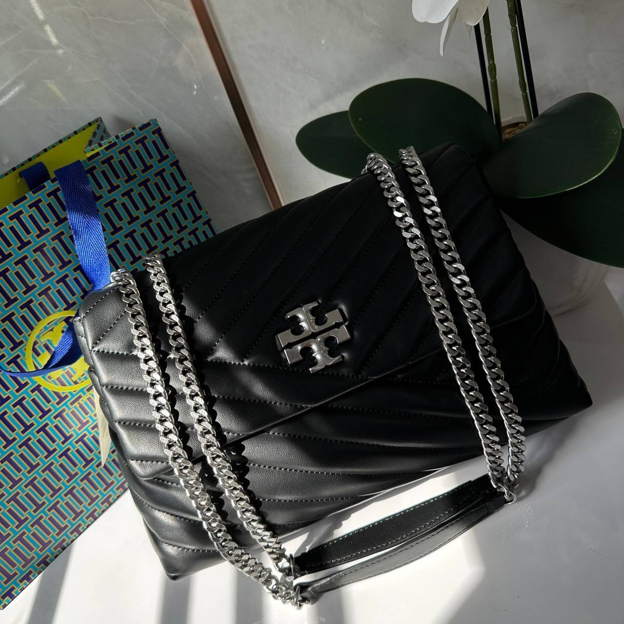 TORY BURCH KIRA CHEVRON CONVERTIBLE SHOULDER BAG กระเป๋าสะพายไซส์ใหญ่ หรูหราสุดคลาสสิก วัสดุหนังแกะทั้งใบ เปิด-ปิดด้วยกระดุมแม่เหล็ก ภายในเป็นช่องโล่ง ใส่ของสำคัญได้ครบ สายสะพายในตัวปรับได้ 2 แบบ สะพายไหล่โซ่คู่หรือจะ ครอสบอดี้ก็เริ่ดคะ