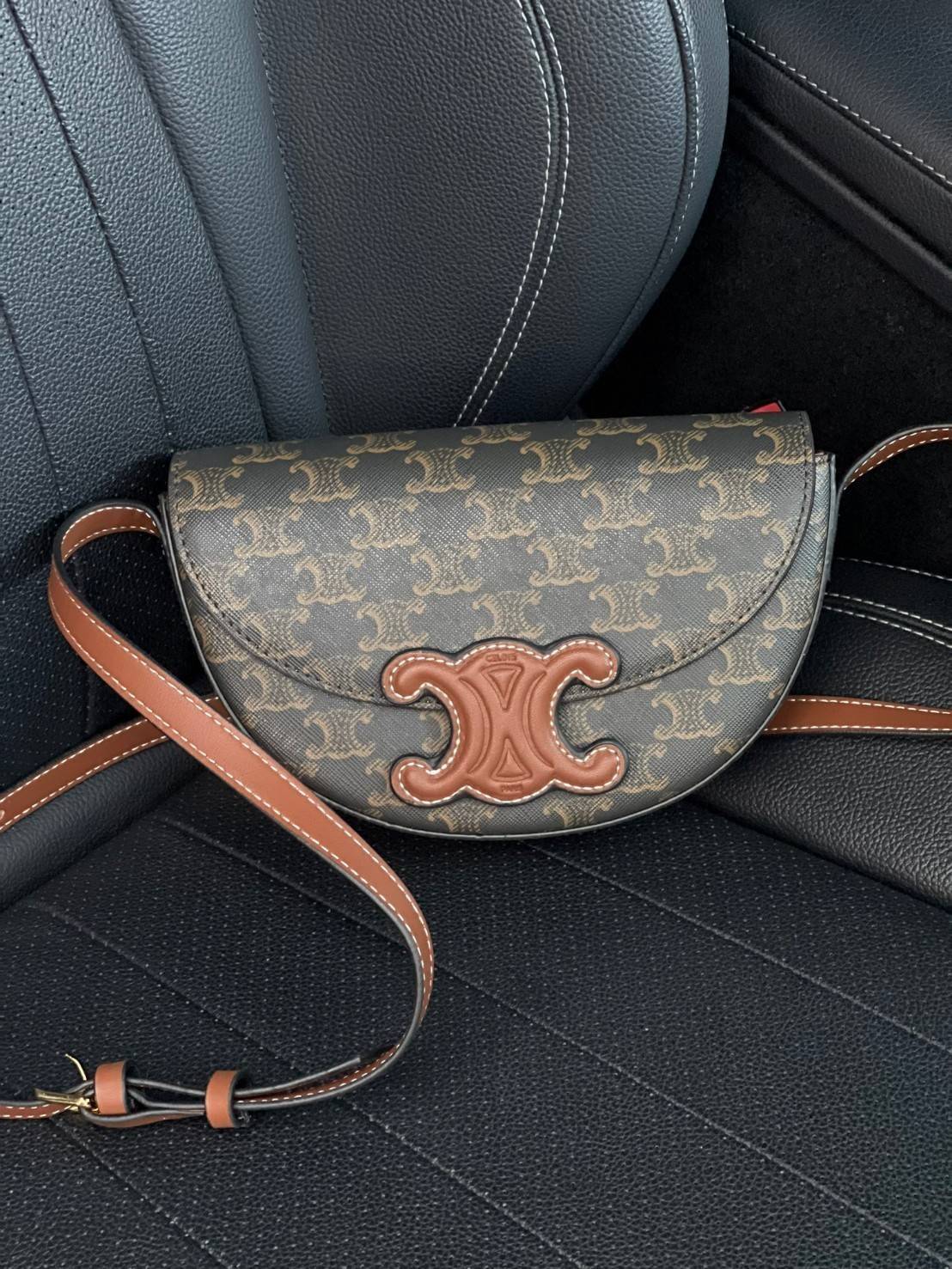 CELINE BESACE CUIR TRIOMPHE IN SMOOTH กระเป๋ารุ่นนี้นำเสนอในรูปทรงฮาล์ฟมูนที่ตอนนี้กำลังงมาแรง เปิดด้วยกระดุมแป๊กเพื่อเผยให้เห็นช่องภายในที่กว้างขวางและกระเป๋าด้านในแบบแบน คุณสมบัติที่โดดเด่นอีกอย่างของกระเป๋าอยู่ที่โลโก้ขนาดใหญ่ รูปทรงสะดุดตา สามารถสะพาย