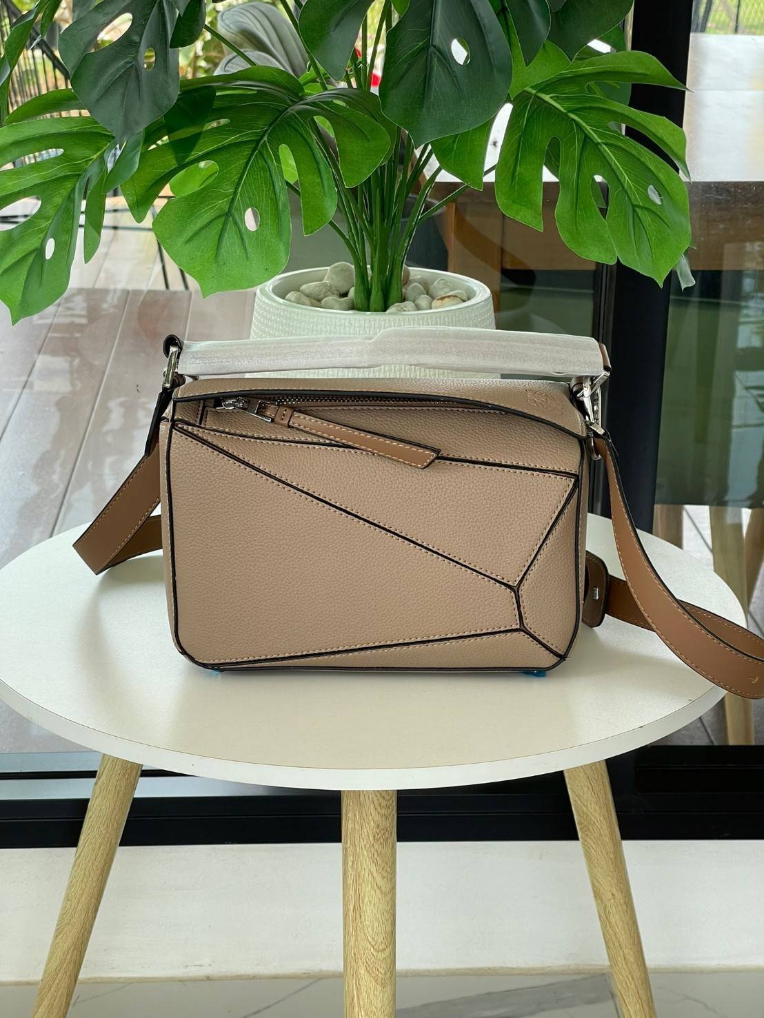 Loewe Puzzle Bag In Classic กระเป๋าทรง Puzzle นี้ออกแบบโดย Jonathan Anderson โดยได้รับแรงบันดาลใจในการออกแบบมาจากรูปทรงของลูกรักบี้ ดังนั้น จึงจะเห็นได้ว่าการตัดเย็บและรูปทรงของกระเป๋านั้นคล้ายคลึงกับลูกรักบี้ รูปทรงดูมินิมอลไม่ทิ้งคอนเซ็ปต์ของแบรนด์ สามา