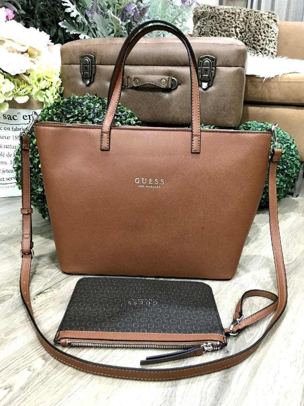 GUESS LARGE SHOPPER BAG WITH POUCH กระเป๋าสะพายรุ่นใหม่ล่าสุดจาก GUESS FACTORY หนัง Saffiano สวยหรูอยู่ทรง ด้านหน้ามีโลโก้แบรนด์ ด้านหลังมีช่องใส่ของ หูหิ้วสะพายไหล่ได้มาพร้อมสายสะพายยาวถอดได้ปรับได้ มีกระเป๋าใบเล็กเข้าชุดกันห้อยที่หูหิ้ว ใบเล็กถอดเเยกใช้
