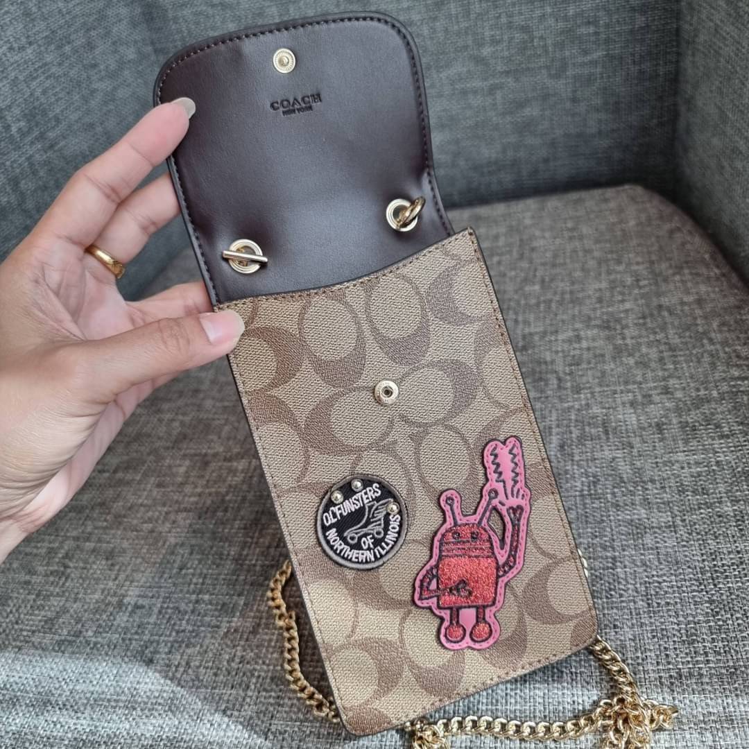 COACH NORTH/SOUTH PHONE CROSSBODY IN SIGNATURE CANVAS F55636 F39955 สุดคลาสสิคกับกระเป๋าสะพายเอนกประสงค์ Case phone ใส่โทรศัพท์มือถือได้ทุกรุ่น ดีไซน์ลายเอกลักษณ์ วัสดุหนังแคนวาสเคลือบลาย ฝาและภายในเป็นหนังสังเคราะห์เรียบ เปิด-ปิดด้วยกระดุม สายสะพายยาวประ