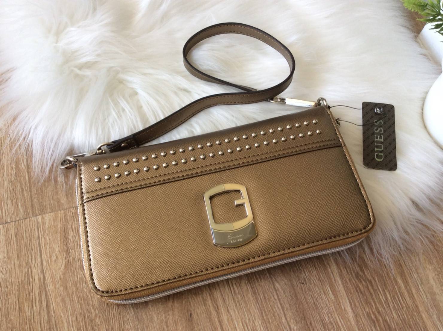 GUESS FACTORY WOMEN'S SAFFIANO LONG WALLET กระเป๋าสตางค์ใบยาวพร้อมสายคล้องมือวัสดุหนัง Saffiano สไตล์ PRADA สวยหรูอยู่ทรง ด้านหน้าประดับโลโก้แบรนด์และแต่งหมุดสุดชิคสวยน่าใช้ ภายในมีช่องใส่แบงก์ ช่องซิป และช่องใส่บัตรหลายช่อง สามารถใส่มือถือ iphone8+ 