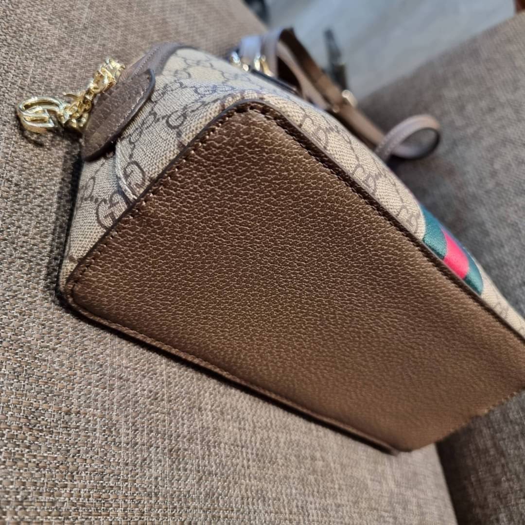 GC CLASSIC SATCHEL BAG กระเป๋าถือ/สะพายทรงโดม รุ่นหายาก สวยคลาสสิค แถมฟรี!! โบว์ผ้าลายแบรนด์ สำหรับตกแต่งหูกระเป๋า ผูกเป็นโบว์ หรือพันถนอมหูกระเป๋าก็เพิ่มดีเทลความหรูได้ วัสดุหนังแคนวาส ดีไซน์แถบคาดโดดเด่น เปิด-ปิดกระเป๋าด้วยซิป หัวซิปตัว G อะไหล่สีทอง เล