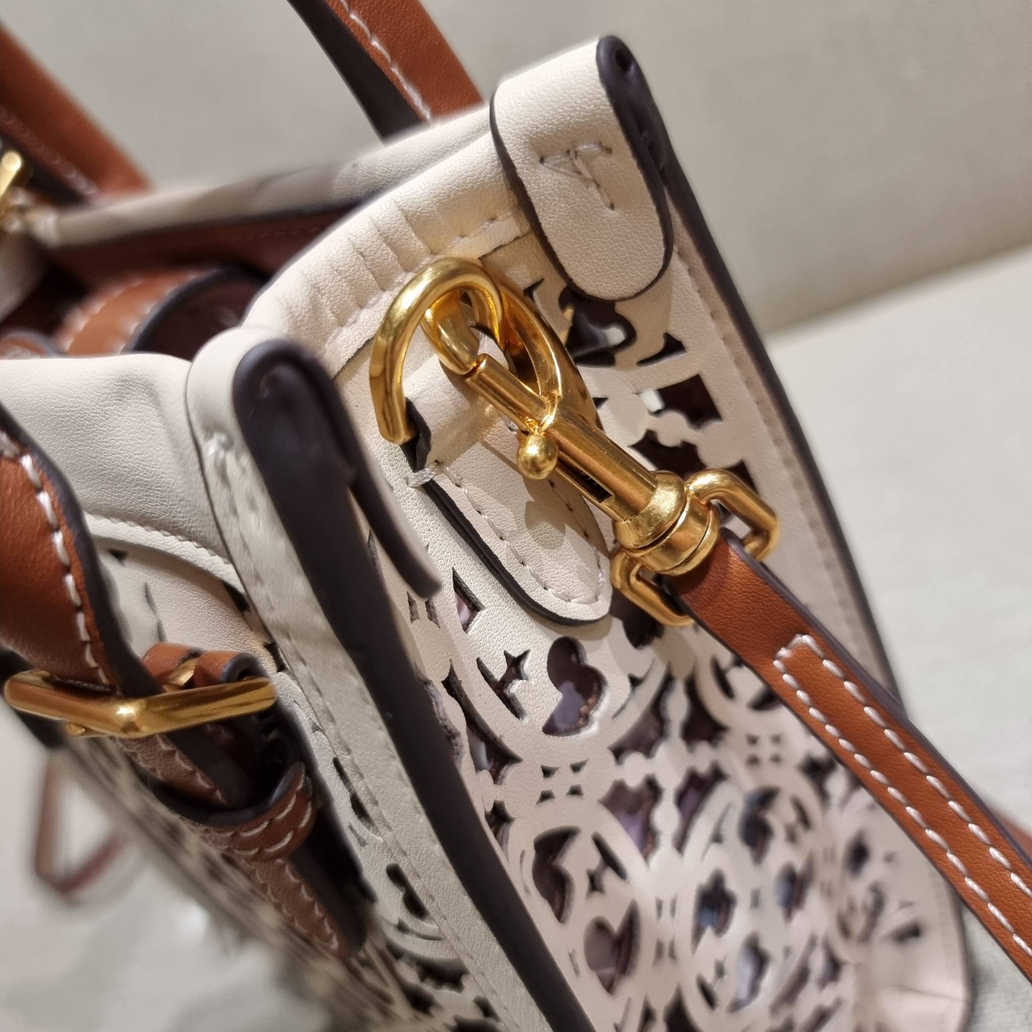 TORY BURCH T MONOGRAM LASER-CUT MINI TOTE ใจบางที่สุดกับคอลเลคชั่นนี้ กับกระเป๋าสะพายทรงโท้ท ไซส์มินิ ที่เพิ่มดีเทลความแพงด้วยการฉลุลวดลายโมโนแกรมรอบใบ ถักทอเป็นเส้นลายสานที่สวยงามมาก งานฝีมือจริงๆ วัสดุหนัง cowhide ปากกระเป๋ามีแถบแม่เหล็กกันหล่น และมีหูจ