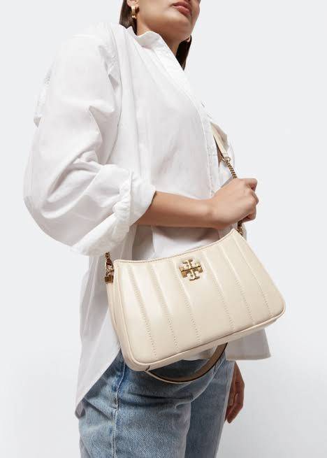 Tory burch Kira logo-plaque crossbody bag กระเป๋า Kira ของ Tory Burch เป็นส่วนหนึ่งของคอลเล็กชั่นที่โดดเด่น และมีหลายรุ่นด้วยกัน โดยมีป้ายโลโก้ Double T ของแบรนด์อยู่ตรงกลาง มีความเรียบง่ายแต่ยังคงความหรูหราโดดเด่นด้วยวัสดุบุผิว ป้ายโลโก้สีทอง สายสะพายโซ่