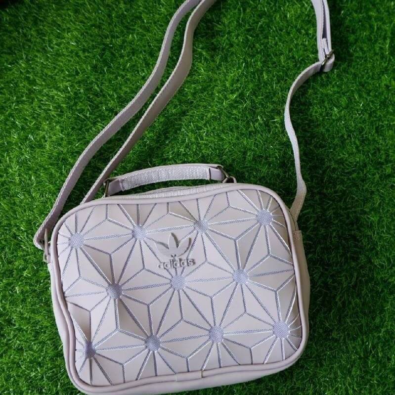adidas mini airline bag *outlet* กระเป๋าสะพายข้างทรงสปอร์ต ด้านหน้าติดโลโก้แบรนด์ ดีไซน์ลาย 3D ด้านหลังเป็นหนังเรียบ มีช่องซิปสามารถใส่สิ่งของได้ รุ่นนี้เปิดปิดด้วยซิปคู่ ซิปปั๊มแบรนด์ทุกจุด ด้านในเป็นช่องกว้าง มีช่องซิป สายสะพายยาวสามารถปรับระดับได้ สาวก