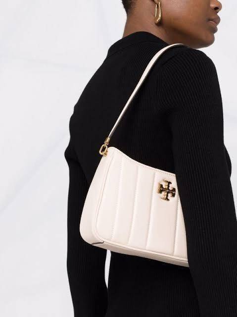 Tory burch Kira logo-plaque crossbody bag กระเป๋า Kira ของ Tory Burch เป็นส่วนหนึ่งของคอลเล็กชั่นที่โดดเด่น และมีหลายรุ่นด้วยกัน โดยมีป้ายโลโก้ Double T ของแบรนด์อยู่ตรงกลาง มีความเรียบง่ายแต่ยังคงความหรูหราโดดเด่นด้วยวัสดุบุผิว ป้ายโลโก้สีทอง สายสะพายโซ่