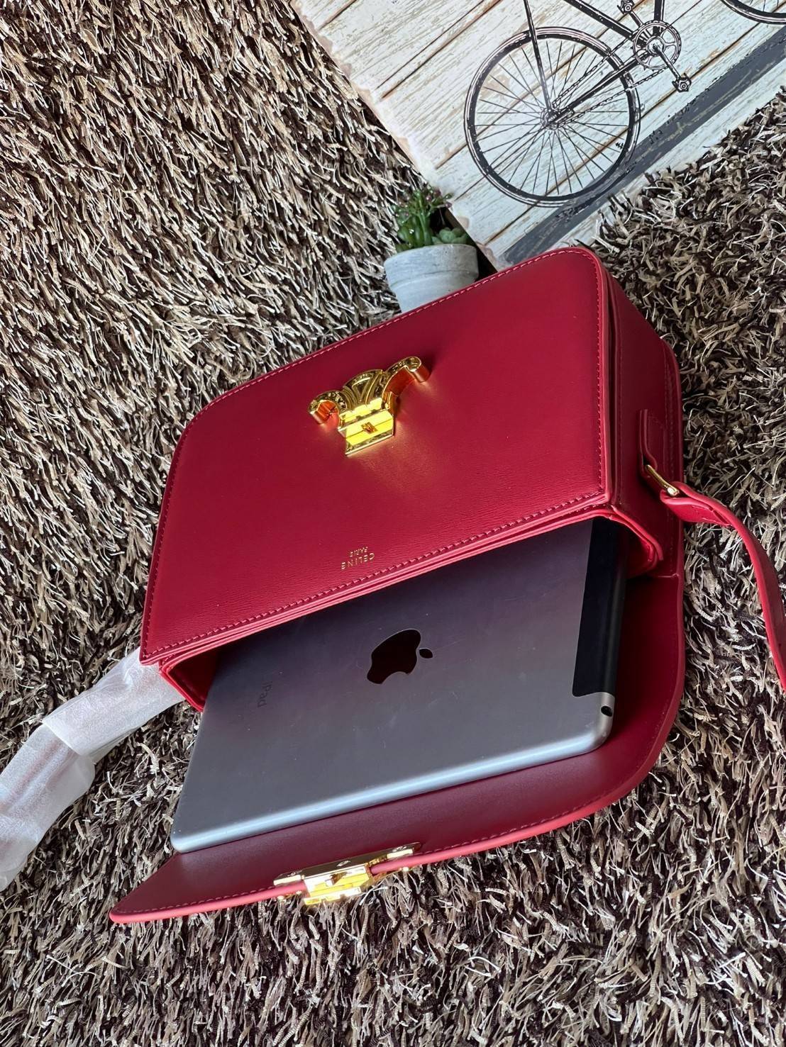 Celine MEDIUM TRIOMPHE BAG IN SHINY มีรูปทรงเป็นกล่องคล้ายกับกระเป๋า Classic Box แต่มีการออกแบบโลโก้ที่สะดุดตาแบบวินเทจ ด้วยดีไซน์ที่ดูโฉบเฉี่ยว แต่คงความคลาสสิคอย่างเต็มเปี่ยม ทำให้เป็นที่ดึงดูดความสนใจของสาวๆ สายสะพายสามารถปรับระดับได้ มีความคล่องตัวในก