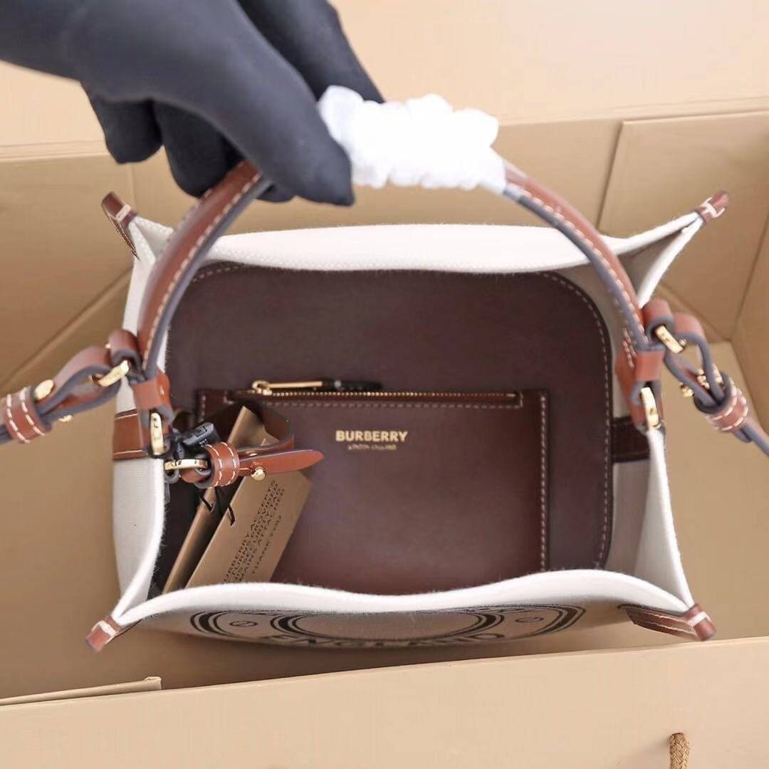 หนังแท้ BURBERRY FRAGRANCES CROSSBODY BUCKET BAG วัสดุ Canvas & Leather สวยหรูอยู่ทรงมาพร้อมกระเป๋าคลัชใบเล็กสีน้ำตาลเข้าชุด ภายในโล่งกว้างและจุ สามารถใส่กล้อง มือถือ ของใช้ได้เยอะ มือจับหนังแข็งแรงหิ้วถนัดมือพร้อมสายสะพายหนังยาวปรับระดับได้ อะไหล่แบรนด์ส