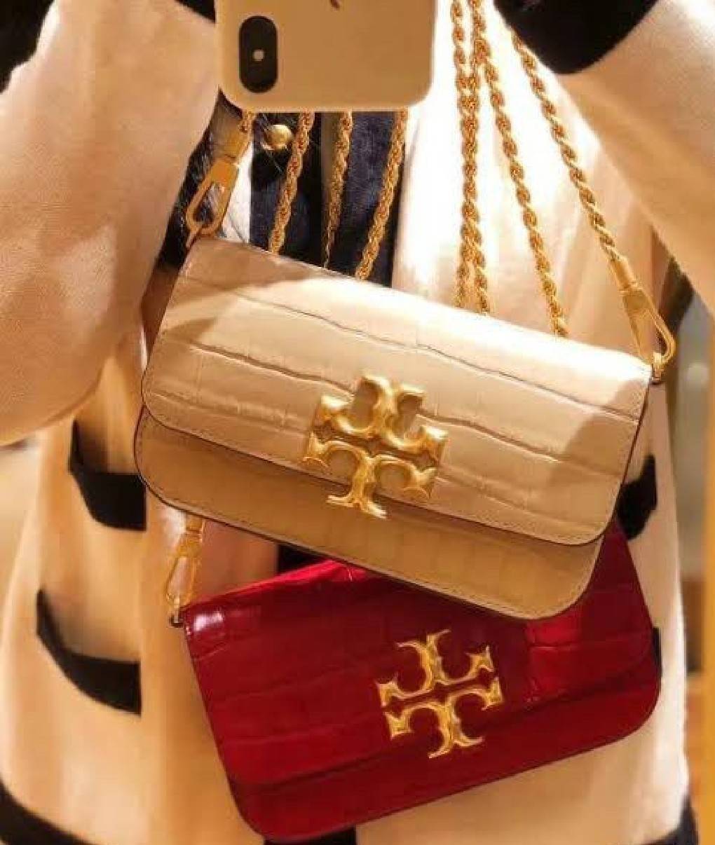 Tory Burch Eleanor Crocodile-Embossed Phone Crossbody Bag จุดเด่นของรุ่นนี้คือดีไซน์ออกมาในสไตล์คลาสสิกที่มาพร้อมกับฮาร์ดแวร์ที่ทำจากวัสดุทองเหลืองและสายสะพายโซ่เกลียวสีทอง ซึ่งการออกแบบได้รับแรงบันดาลใจมาจากเครื่องประดับ รูปทรงกะทัดรัดจึงสามารถสะพายใช้งา