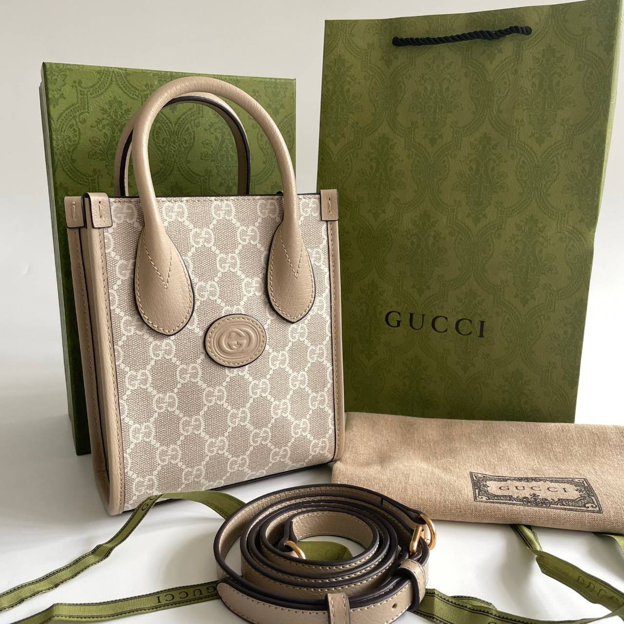หนังแท้ GUCCI Mini tote bag with Interlocking G พร้อมส่งที่ไทย Beige and white GG Supreme canvas เกรดออริจินอล ภาพสินค้าถ่ายจากงานขายจริง ใช้งานต่างประเทศได้ The mini tote bag is complete with an oatmeal leather trim and an Interlocking G tag.