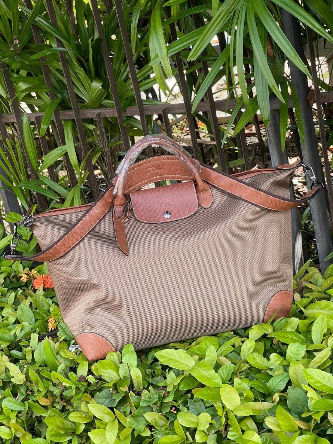 LONGCHAMP BOXFORD TRAVEL BAG L กระเป๋าเดินทางขนาดใหญ่ มาพร้อมสายสะพายที่สามารถถอดได้ ให้คุณเลือกสะพายไหล่หรือถือได้ มีซิปรูดเปิดปิดกระเป๋าที่ให้คุณมั่นใจได้ว่าคุณจัดเก็บไอเท็มของคุณได้อย่างมิดชิด บ็อคฟอร์ด (BOXFORD) สะท้อนความเป็นเอกลักษณ์ของแบรนด์ที่เปี่