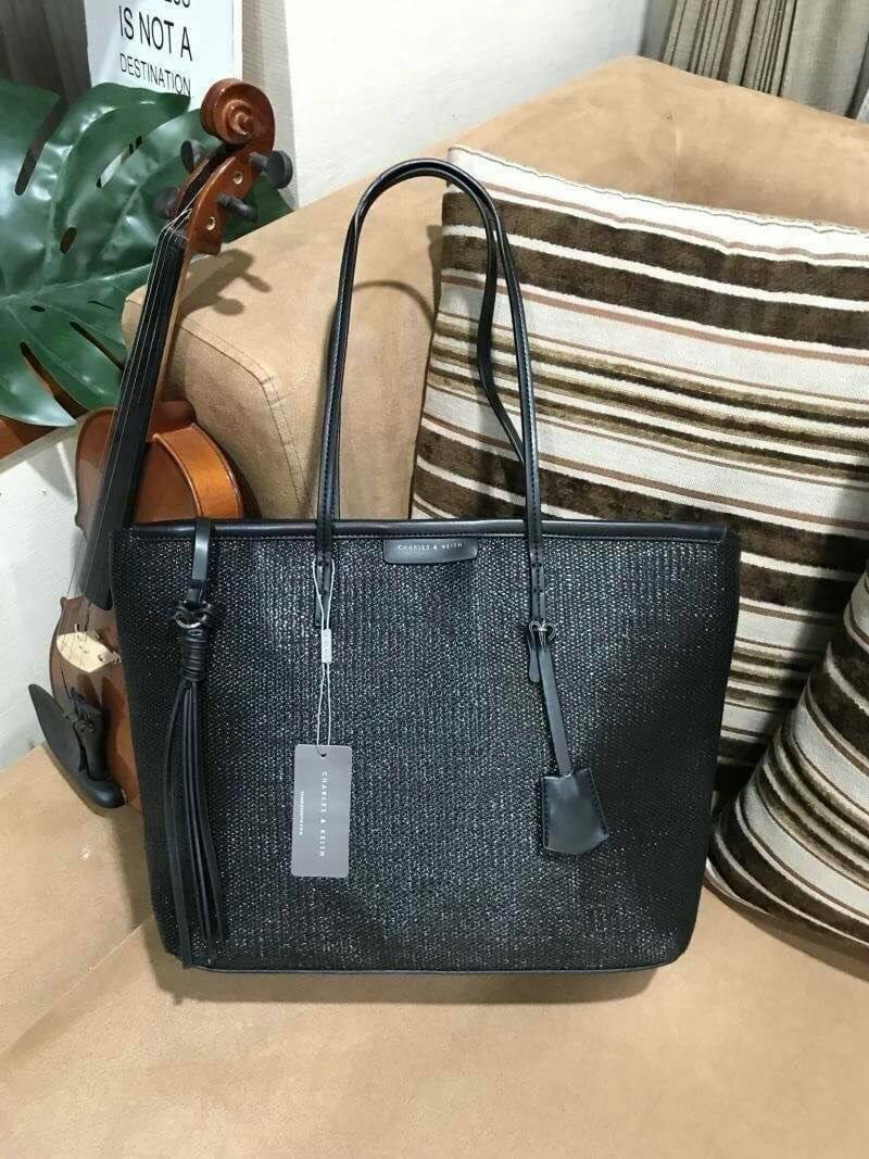 Charles & Keith Black Textured Tote Bag กระเป๋าสะพายทรง Shopping ใบใหญ่จุใจโดดเด่นด้วย Textured สานรอบใบสวยอยู่ทรง น้ำหนักเบา ด้านหน้ามีโลโก้พร้อมTAG พวงกุญแจห้อยที่หูหิ้ว เปิดปิดด้วยซิปพู่หนังสายยาว ภายในกว้างและจุ มีช่องใส่ของและช่องซิป ใส่เอกสารA4 ipad