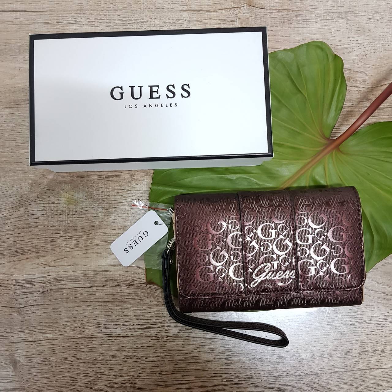 Guess leather wallet กระเป๋าสตางค์ใบกลาง มีสายคล้องมือสามารถถอดได้ ด้านหน้าแต่งโลโก้แบรนด์โลหะสีเงิน ภายในมีช่องใส่ธนบัตร,เหรียญ บัตรต่างๆ ปิดเปิดใช้งานสะดวก