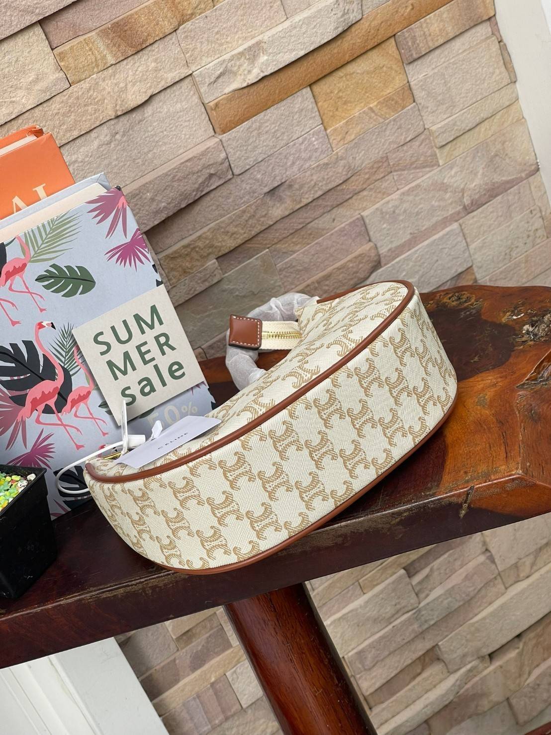 CELINE Vintage Classic Ava bag 1 ใน คอลเลคชั่น “Triomphe Canvas” มาพร้อมสายสะพายไหล่ที่ปรับความยาวได้ และเนื่องจากช่วงล่างของกระเป๋ามีขนาดใหญ่กว่าช่วงบน จึงทำให้ไม่เสียทรงเมื่อเราใส่สิ่งของอย่างกระเป๋าสตางค์หรือโทรศัพท์มือถือ หากดูภาพรวมแล้ว รุ่นนี้ออกแนว