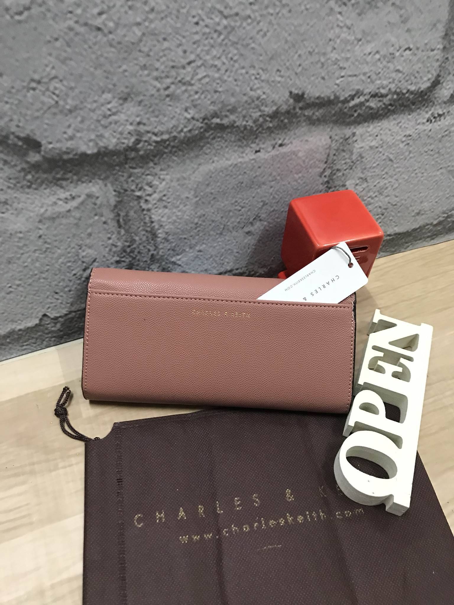 CHARLES & KEITH CIRCULAR DETAIL WALLET กระเป๋าสตางค์ทรงยาว วัสดุหนังpuที่มีทั้งแบบหนังเรียบและหนังลายคาร์เวียร์ เปิดปิดด้วยกระดุมแม่เหล็ก ภายในแยกเป็นช่องใส่บัตร,ธนบัตรและช่องซิปใส่เหรียญ ด้านหลังมีช่องใส่ของอีก1ช่อง ด้านหน้าดีไซน์เรียบง่ายแต่ดูหรู คอลเลค