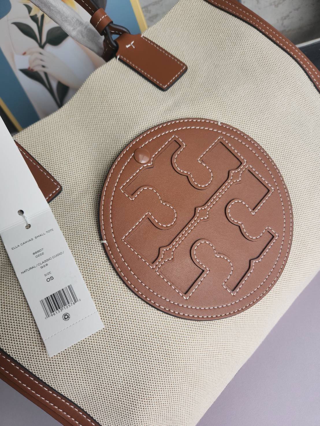 TORY BURCH ELLA CANVAS TOTE BAG กระเป๋าโท้ตน้ำหนักเบาของเราพร้อมป้ายโลโก้ Ella ทำจากผ้าใบที่ทนทานพร้อมรายละเอียดหนังและกระเป๋าด้านใน อเนกประสงค์ ทรงคลาสสิก และสร้างขึ้นอย่างสวยงามด้วยฝีมือช่างฝีมือ สายรัดแคบช่วยให้วางราบกับไหล่ได้อย่างสบาย เหมาะสำหรับทุกว