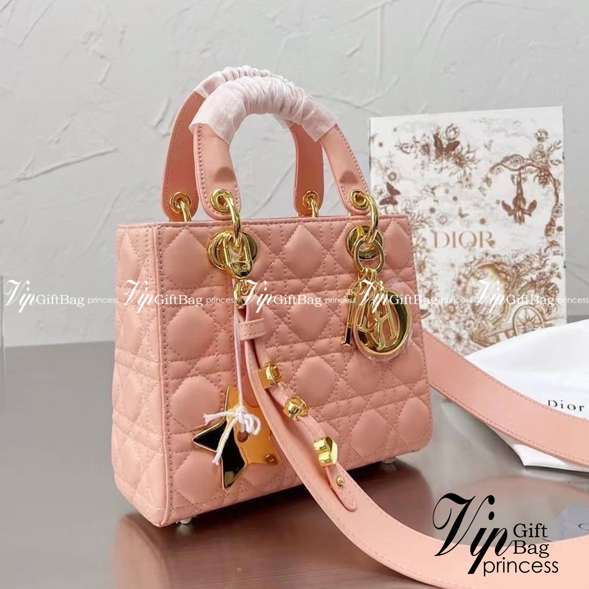 DIOR Lady / Small Lady Dior Bag Cannage Lambskin กระเป๋าสุดไอคอนิก รูปทรงสีเหลียม ขนาดกระทัดรัด ตั้งอยู่ทรง ฐานกระเป๋าแข็งแรง มีหมุดรองฐาน ดีไซน์เอกลักษณ์เฉพาะตัว ด้านหน้าตกแต่งด้วยตัวอักษร D.I.R ห้อยเป็นพวงกุญแจ จะถือหรือสะพายไหล่ก็ดูดีมากๆ ค่ะ