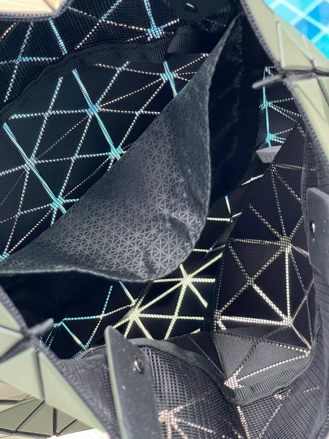 Baobao Issey Miyake Prism Kangaroo tote bag กระเป๋าถือทรงโท้ทที่ประดิษฐ์ขึ้นอย่างเชี่ยวชาญในญี่ปุ่น มาพร้อมแผงเรขาคณิตสำหรับการออกแบบที่ได้รับแรงบันดาลใจจากกระดาษพับ ซิลลูเอทอันเป็นเอกลักษณ์นี้ปิดท้ายด้วยสายรัดแบบอสมมาตร มีการพัฒนาโครงสร้างทรงสามเหลี่ยมเพ