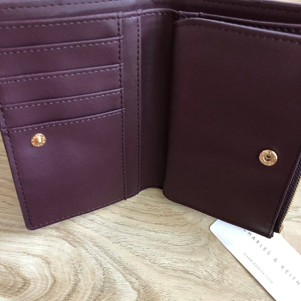 Charles & Keith Classic Snap-Button Wallet กระเป๋าสตางค์ใบสั้นพับ 2 ตอน ด้านหน้ามีโลโก้แบรนด์ เปิด - ปิดด้วยกระดุม ภายในมีช่องใส่ธนบัตร ช่องใส่บัตร และช่องซิปใส่เหรียญ