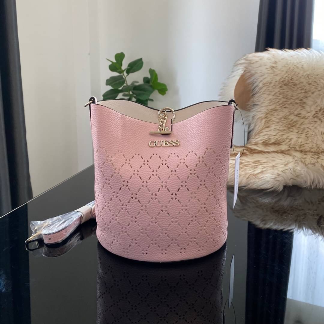 Guess Amara Bucket Handbag ซื้อ 1 ได้ถึง 2 กระเป๋ารุ่นใหม่ล่าสุดทรงถังสุดน่ารัก พิมพ์ลายรอบใบ วัสดุหนังนิ่มคุณภาพดี นิ่ม น้ำหนักเบา ด้านหน้าประดับด้วยโลโก้แบรนด์สวยโดดเด่น เปิด-ปิดด้วยด้วยตัวคล้องอะไหล่เงินสะดวกใช้ ด้านในโล่ง มีสายยาวปรับระดับได้มาให้ มาพ
