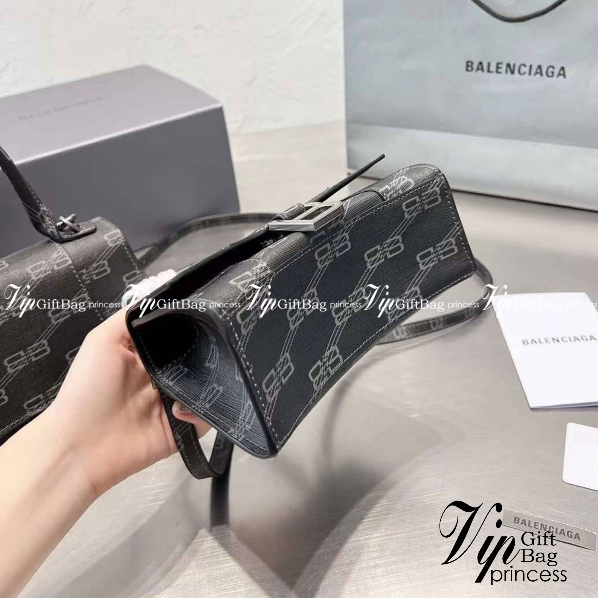 BALENCIAGA Hourglass BB Monogram top-handle tote bag กระเป๋าสะพายแบรนด์หรูซิกเนเจอร์ใบล่าสุด ที่มาพร้อมดีไซน์โดดเด่น มีความโฉบเฉี่ยว โค้งมนเหมือนพระจันทร์เสี้ยว เพิ่มความโดดเด่นสะดุดตาด้วยการตกแต่งอักษร B เมทัลลิก ที่เป็นเอกลักษณ์แบรนด์ งานจริงสวยงามตามรู