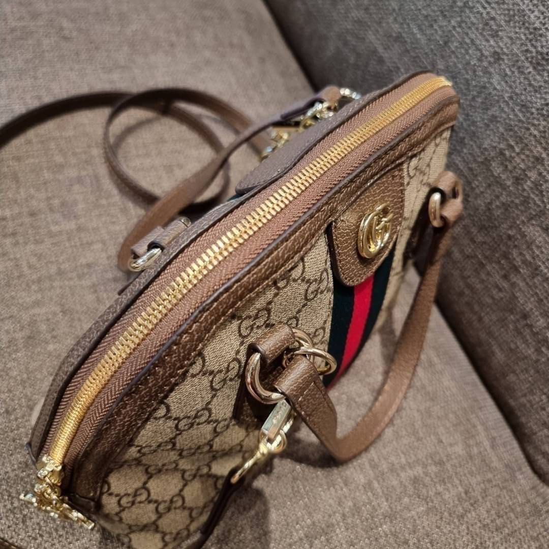 GC CLASSIC SATCHEL BAG กระเป๋าถือ/สะพายทรงโดม รุ่นหายาก สวยคลาสสิค แถมฟรี!! โบว์ผ้าลายแบรนด์ สำหรับตกแต่งหูกระเป๋า ผูกเป็นโบว์ หรือพันถนอมหูกระเป๋าก็เพิ่มดีเทลความหรูได้ วัสดุหนังแคนวาส ดีไซน์แถบคาดโดดเด่น เปิด-ปิดกระเป๋าด้วยซิป หัวซิปตัว G อะไหล่สีทอง เล