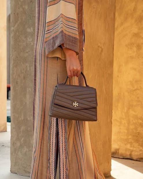 TORY BURCH Kira Chevron Top-handle Satchel กระเป๋าหนังแกะ สัมผัสนุ่มควบคู่กับดีไซน์อันเป็นเอกลักษณ์ กระเป๋าถือทรงสวยที่มีดีไซน์อันเป็นเอกลักษณ์ไม่เหมือนกับที่ไหน ด้วยการตัดเย็บหนังแกะแสนนุ่มแบบลายบุสองชั้น เพิ่มมูลค่าด้วยสายสะพายที่ทำจากโลหะสีทอง อีกทั้งย