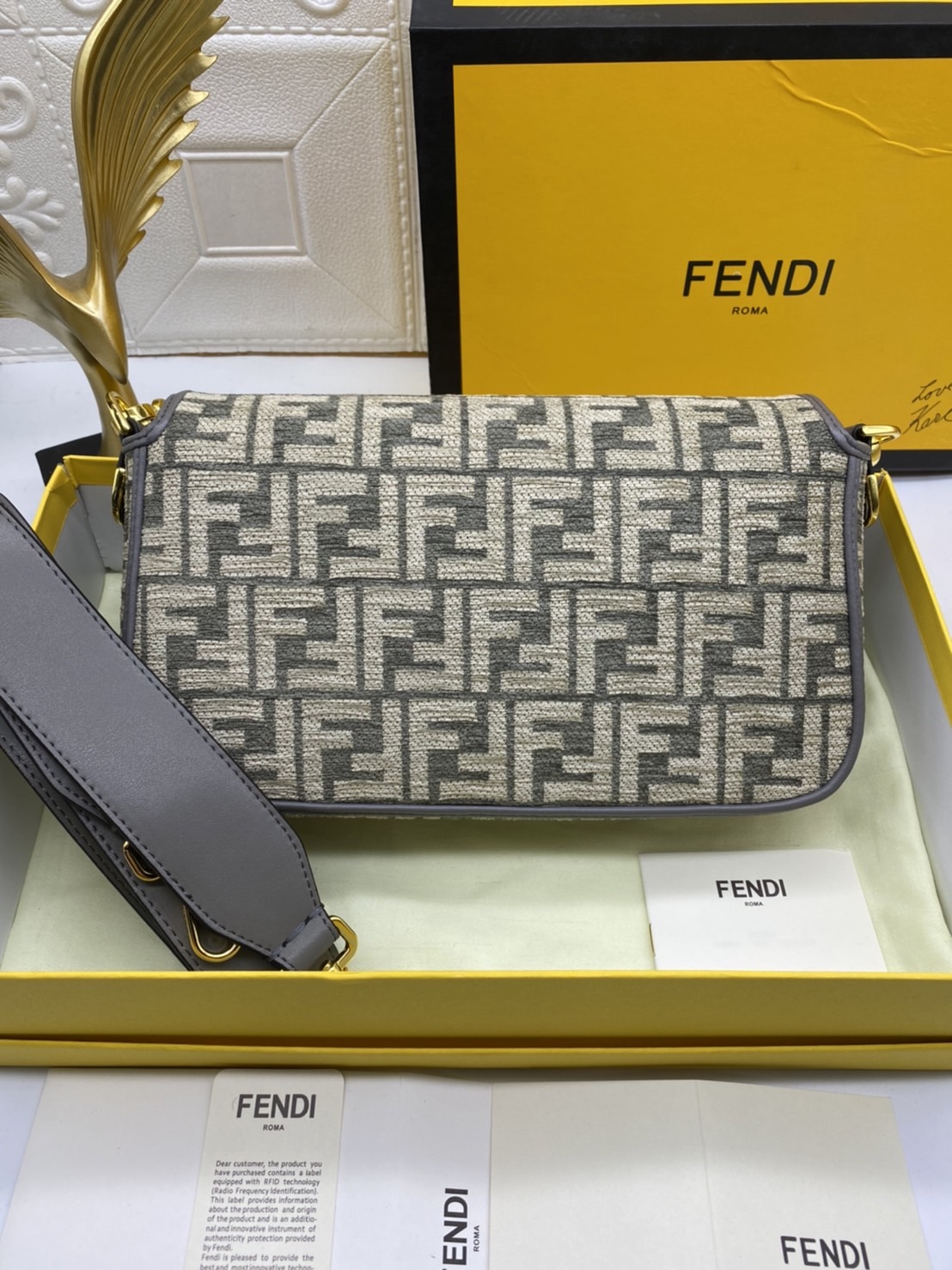 Fendi Baguette FF Tapestry Fabric Bag เกรดออริจินอล กระเป๋าทรง Baguette ขนาดกลาง วัสดุผ้าเซนิล พร้อมลวดลาย FF สีเทาเข้ม ปิดท้ายด้วยรายละเอียดหนังแบบทูโทนและประดับด้วยตัวล็อค FF โดดเด่นด้วยฝาปิดด้านหน้าตัวล็อคแม่เหล็กช่องด้านในบุด้วยผ้าหนังกลับพร้อมกระเป๋า