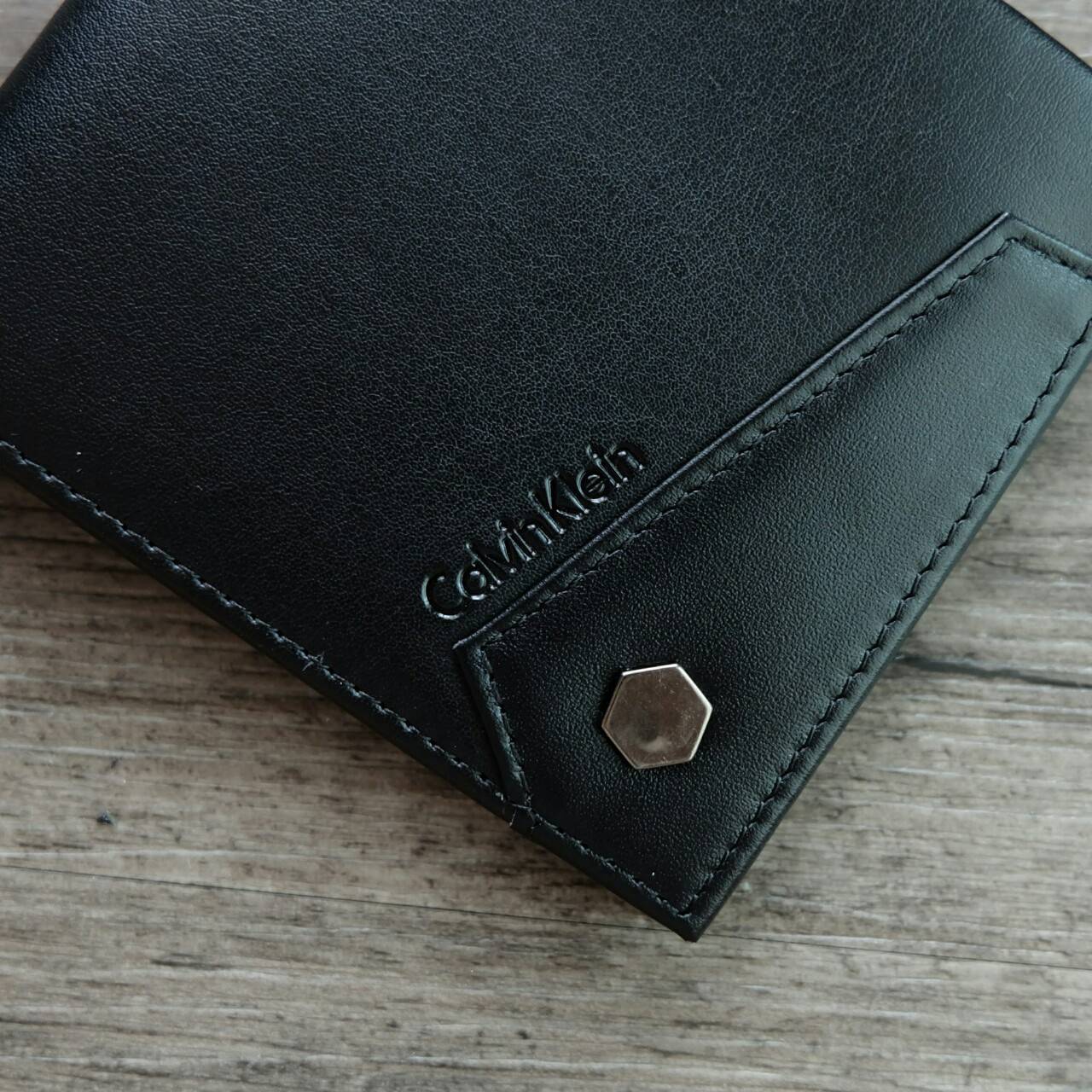 Calvin Klein Short Wallet กระเป๋าสตางค์ใบสั้น ด้านหน้ามีโลโก้แบรนด์ และตกแต่ง ด้วยหมุดโลหะเงิน ภายในมีช่องใส่ธนบัตร ช่องใส่บัตรหลาย ช่อง และช่องใส่รูป จะมอบเป็นของขวัญหรือใช้เองก็แนะนำค่ะ