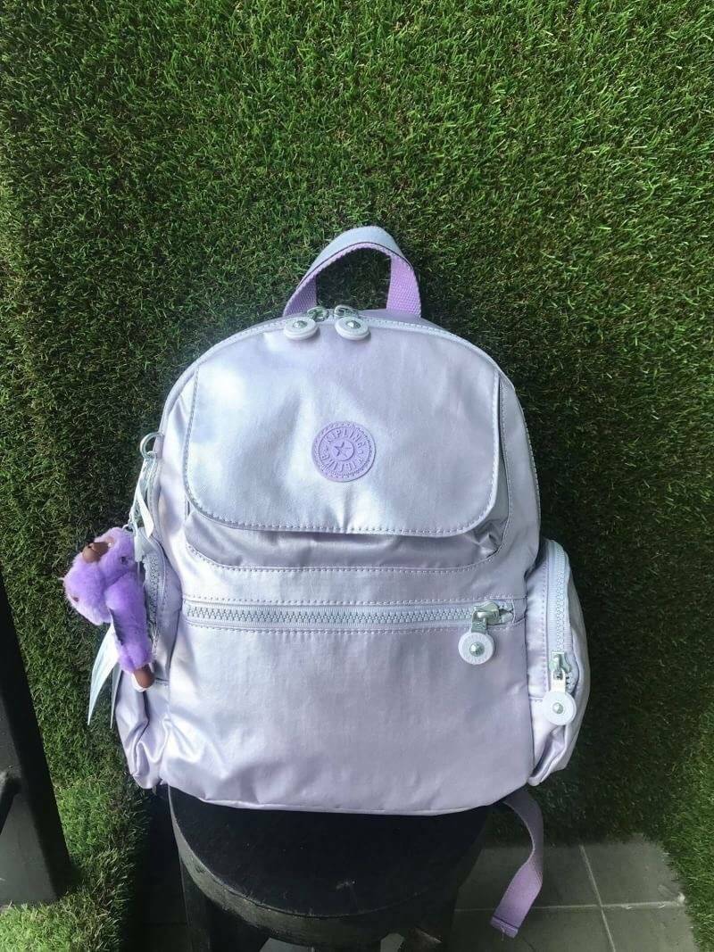Kipling Matta Small Metallic Backpack กระเป๋าเป้ขนาดกำลังดี วัสดุไนล่อนเคลือบกันน้ำ มีน้ำหนักเบา มีช่องเก็บของหลายช่อง แบ่งเป็นช่องด้านหน้า 2 ช่องและด้านข้างอีก 2 ช่อง ช่องใหญ่ปิดเปิดด้วยซิปคู่ภายในมีช่องซิป ช่องใส่ของจุกจิกและสายห้อยพวงกุญแจ ด้านหน้าประด
