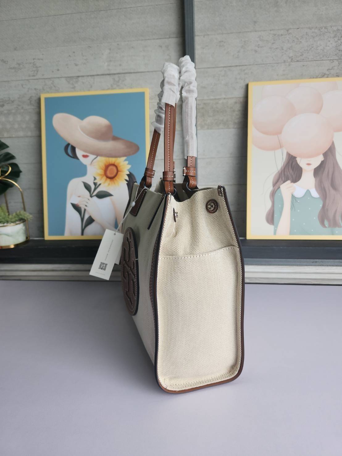 TORY BURCH ELLA CANVAS TOTE BAG กระเป๋าโท้ตน้ำหนักเบาของเราพร้อมป้ายโลโก้ Ella ทำจากผ้าใบที่ทนทานพร้อมรายละเอียดหนังและกระเป๋าด้านใน อเนกประสงค์ ทรงคลาสสิก และสร้างขึ้นอย่างสวยงามด้วยฝีมือช่างฝีมือ สายรัดแคบช่วยให้วางราบกับไหล่ได้อย่างสบาย เหมาะสำหรับทุกว