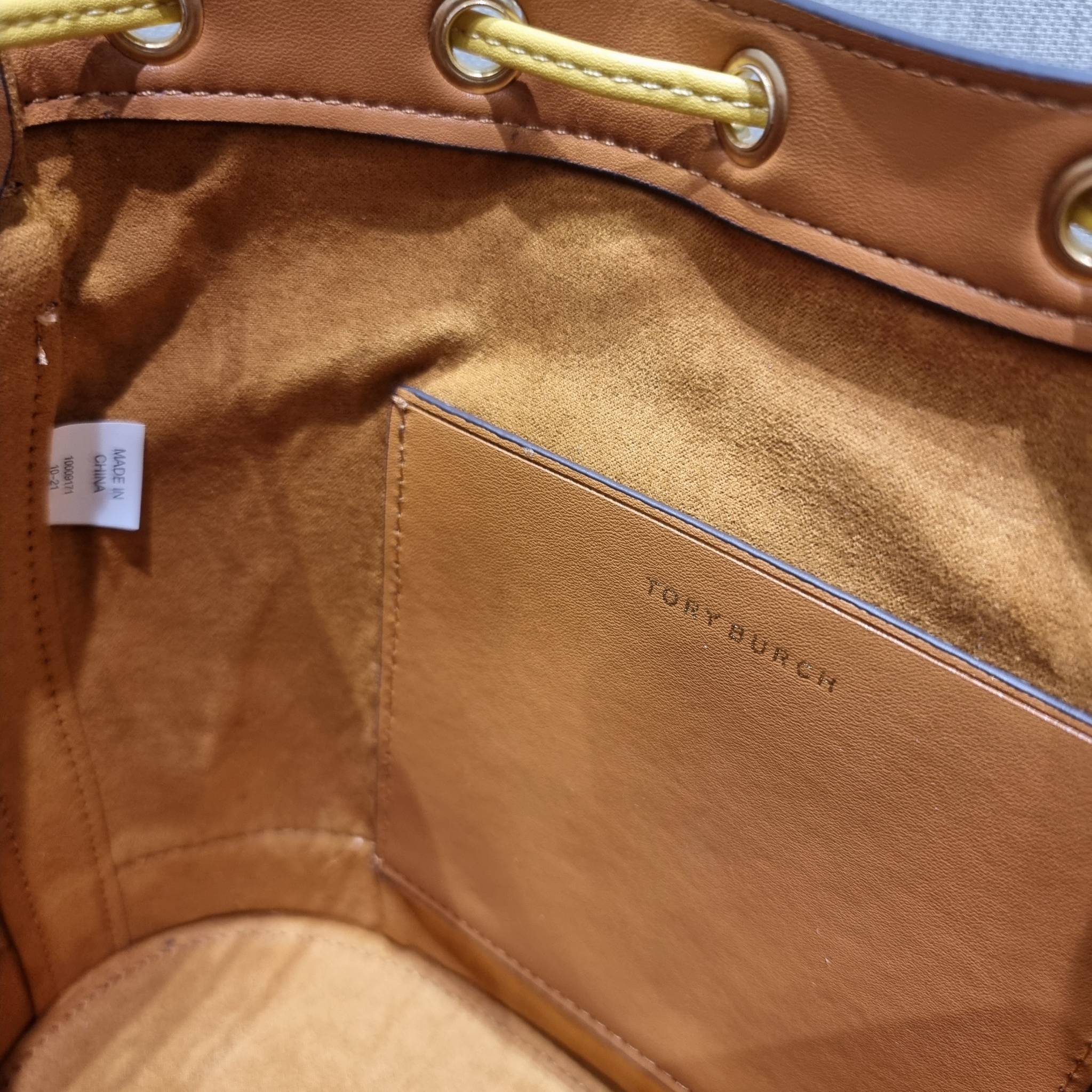 TORY BURCH T MONOGRAM COLORBLOCK JACQUARD BUCKET BAG ไอเท็มใหม่ที่ใครๆก็รอ กระเป๋าบัคเก็ตทรงสวย ที่ยังคงให้ความโดดเด่นด้วยลวดลายเอกลักษณ์ เพิ่มเติมดีไซน์บล็อคสี ตัดกันได้อย่างลงตัว ถักทอบนวัสดุ woven jacquard ลายคมชัด สลับส่วนของหนังแท้ ภายในเป็นช่องโล่งก