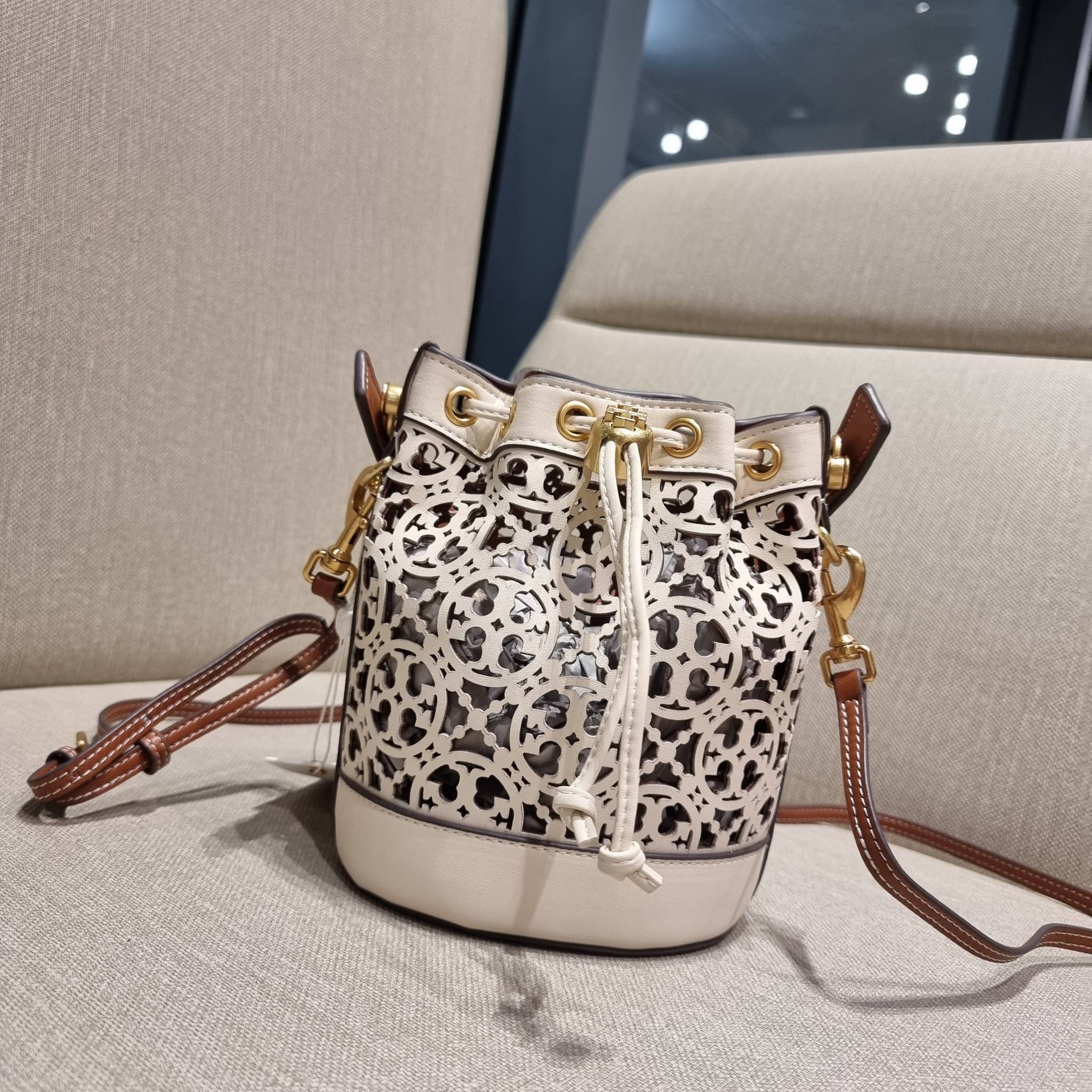 TORY BURCH T MONOGRAM LASER-CUT MINI BUCKET BAG ใจบางที่สุดกับคอลเลคชั่นนี้ กับกระเป๋าสะพายทรงบัคเก็ต ไซส์มินิ รุ่นชูโรงสุดฮิต ที่เพิ่มดีเทลความแพงด้วยการฉลุลวดลายโมโนแกรมรอบใบ ถักทอเป็นเส้นลายสานที่สวยงามมาก งานฝีมือจริงๆ วัสดุหนัง cowhide รูดเปิด-ปิดด้ว