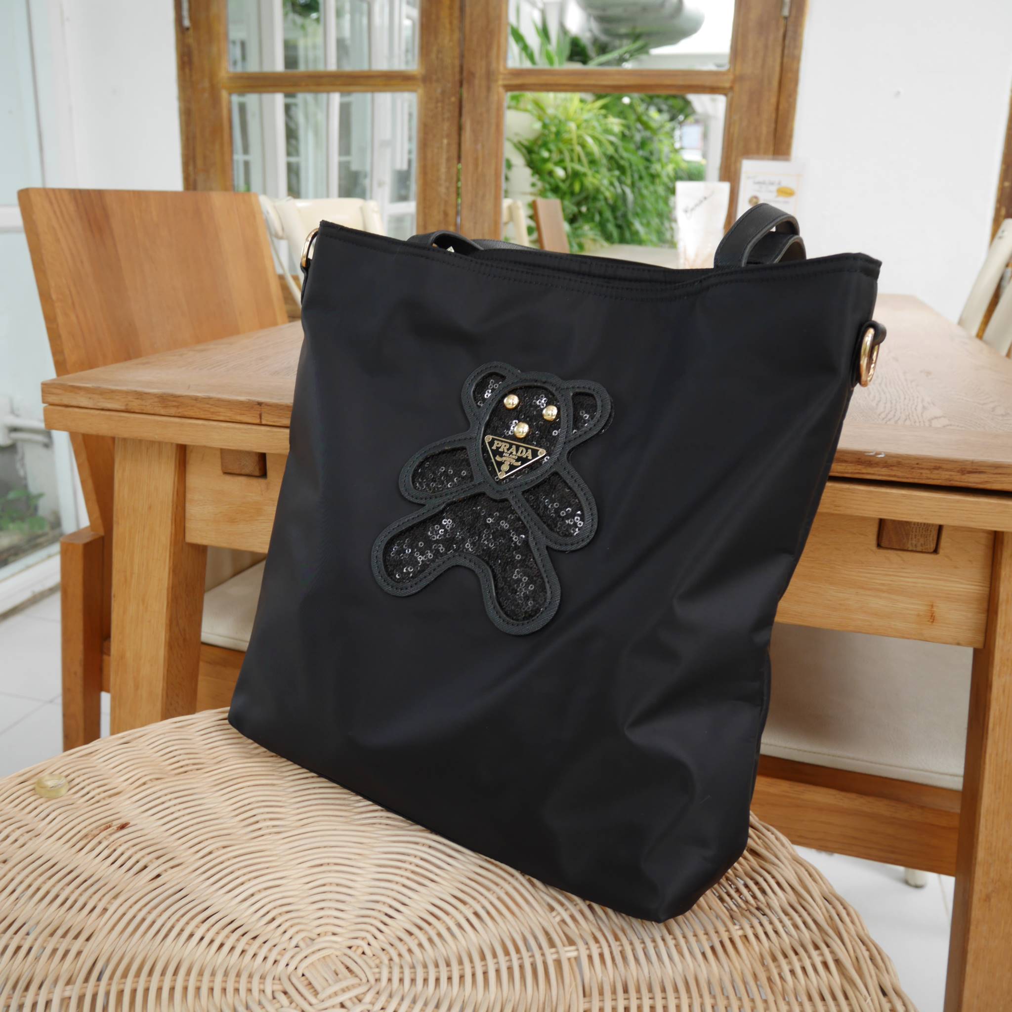 งานขายดีคะ ♡♡ กระเป๋าสะพาย ทรง TOTE จากแบรนด์ PRADA มาค่า ตัวกระเป๋าเป็น nylon ทั้งใบ สะพายเป็น shoulder bag หรือถือได้ค่ะ ด้านหน้าเป็นลายหมี ปักกลิ้ตเตอร์ + logo brand ใช้แล้วสวยมากๆ อะไหล่ทองหรูมาก จุของคุ้ม ใส่หนังสือ หรือ MacBook ได้ค้า 