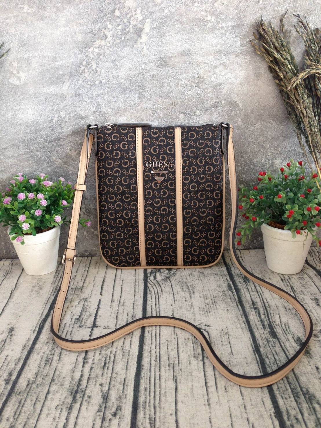 GUESS CROSSBODY กระเป๋าสะพายข้าง ผู้หญิงหรือผู้ชาย สามารถใช้ได้ค่ะ วัสดุหนังแกะสังเคราะห์พิมพ์ลายแบรนด์ ด้านหน้าประดับโลโก้แบรนด์มีเงิน เปิดปิดด้วยซิป น้ำหนักเบา ด้านในบุผ้าพิมพ์ลายเฉพาะของแบรนด์ มีช่องซิปด้านในอีก 1 ช่องค่ะ