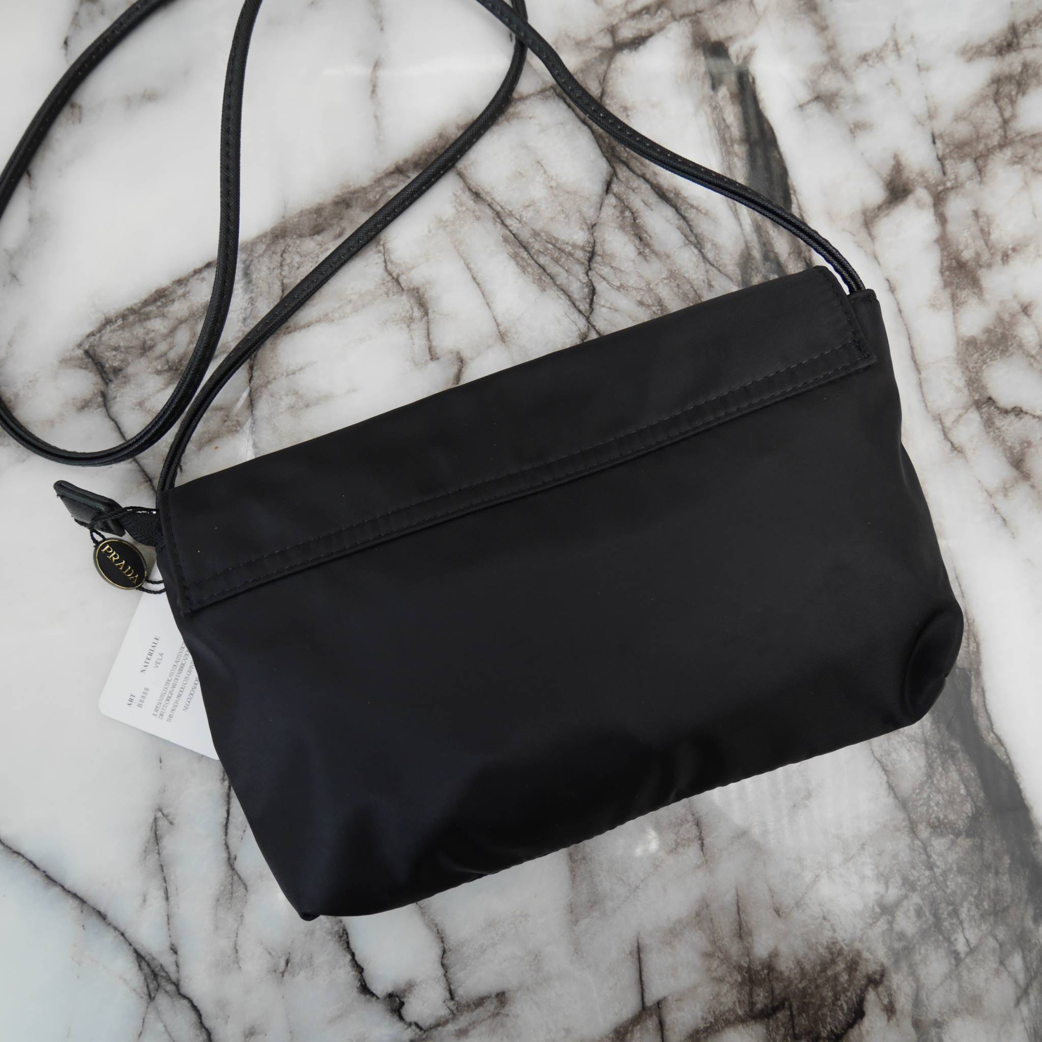 Best Seller! จากงานพรีเมี่ยมกิ้ฟ จากเคาเตอร์ต่างประเทศ จากแบรนด์ PRADA ค่า เป็น กระเป๋าผ้าไนล่อน ตามแบบฉบับของแบรนด์เลย ใบนี้มีสายยาวให้คะ เลิศมาก สะพายเป็น shoulder bag ได้เลย ขนาดกำลังดีคะ ตัวกระเป๋าเบามาก ใส่มือถือได้ทุกรุ่น ใช้แล้วสวยมากๆ อะไหล่ทองหรู