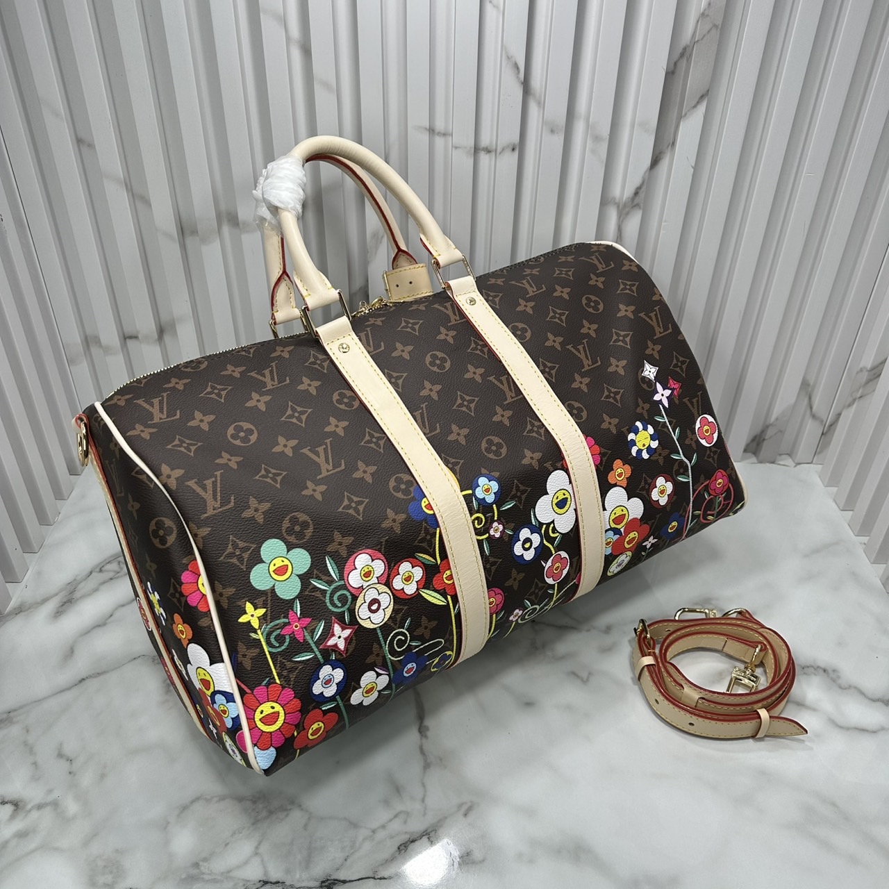 LV x TM Keepall Bandoulière 45 Bag Monogram Flower กระเป๋าเดินทางคอลเลกชันสุดพิเศษ สวยคลาสสิกมีชีวิตชีวา สีสันสดใสสไตล์ superflat สุดไอคอนิกของ Takashi Murakami ด้วยโมโนแกรมดอกไม้หลากสี ปรับดีไซน์ให้ดูสนุกสนาน