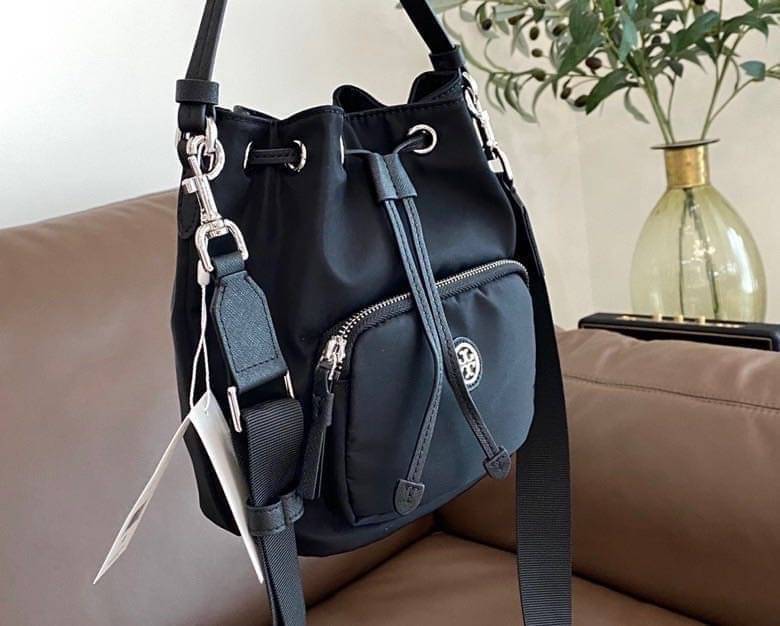 Tory Burch Virginia Nylon Bucket Bag / Tory Burch logo-plaque bucket bag กระเป๋าสะพายทรงบัคเก็ต เปิด-ปิดหนังรูดปากกระเป๋า มีหูหิ้วในตัว คล้องแขนเก๋ๆ ภายในเป็นช่องโล่ง มีช่องย่อย ใส่ของสำคัญจุกจิกได้ มีสายครอส จะสะพายไปไหนก็ได้ทุกโอกาส สวยเลิศทุกสี พร้อมส่